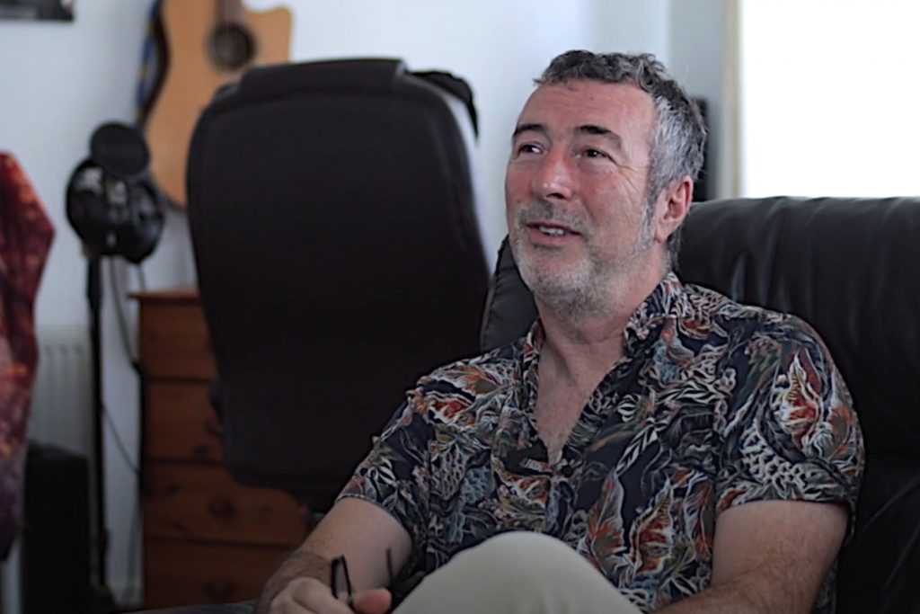 Man with grey hair sitting on sofa