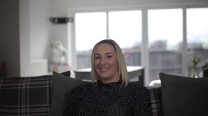 Woman in spotty dress sitting on a sofa