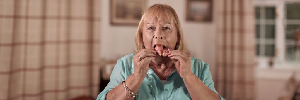 A woman removing her obturator from her mouth