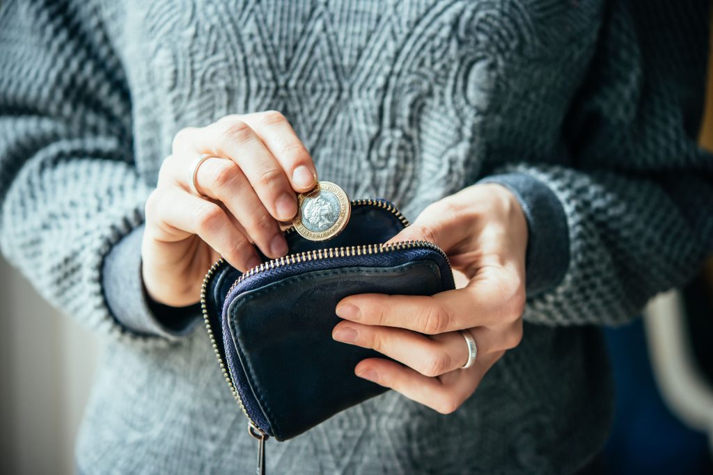 Lady in grey jumper putting coins into her purse