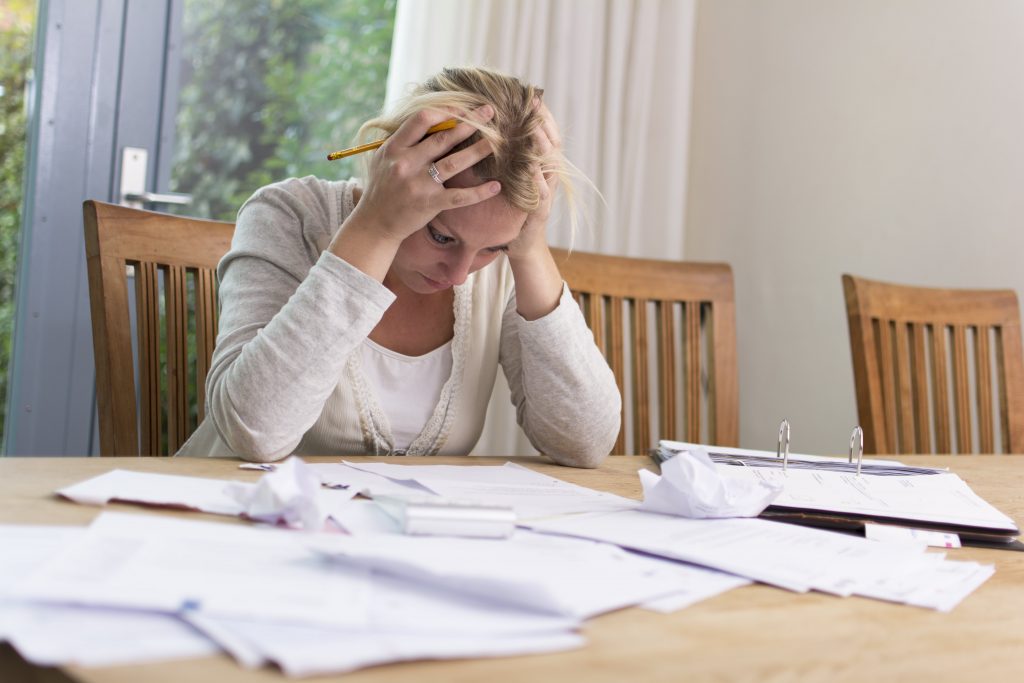 lady looking anxious with paperwork all around her