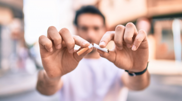 Man holding cigarette snapped in half