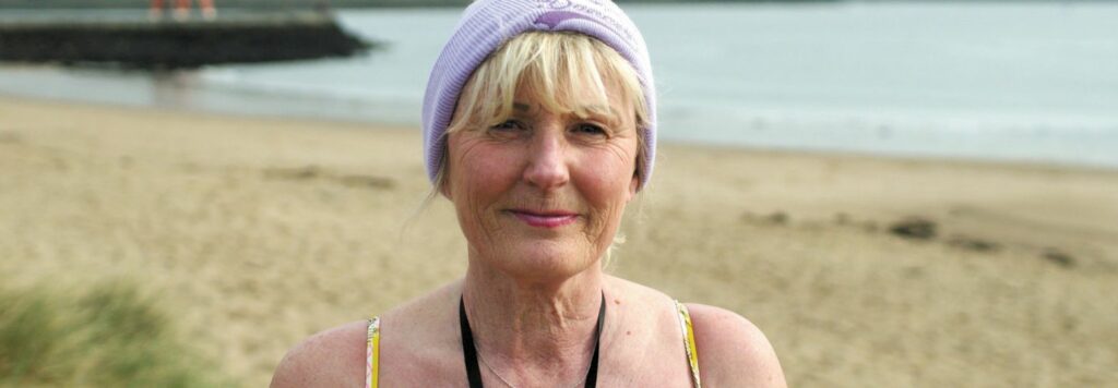 A woman in a swimsuit standing in front of the sea